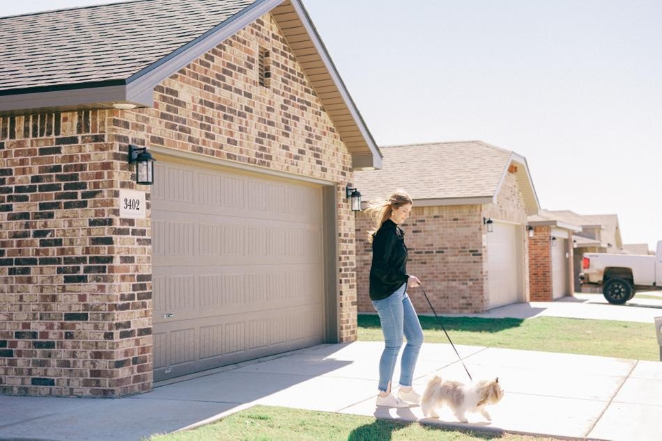 Dog Comp Photo of a woman walking her dog in a Betenbough Homes Amarillo community.