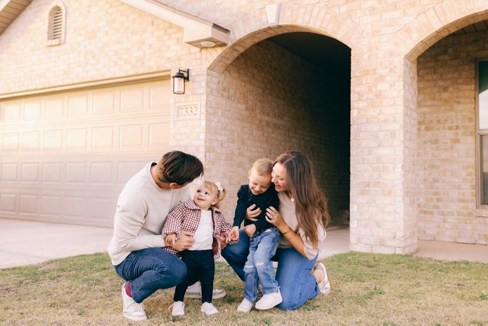 Family Yard Comp Photo of a mom and dad with their two children in the front yard of their Betenbough home in Amarillo.