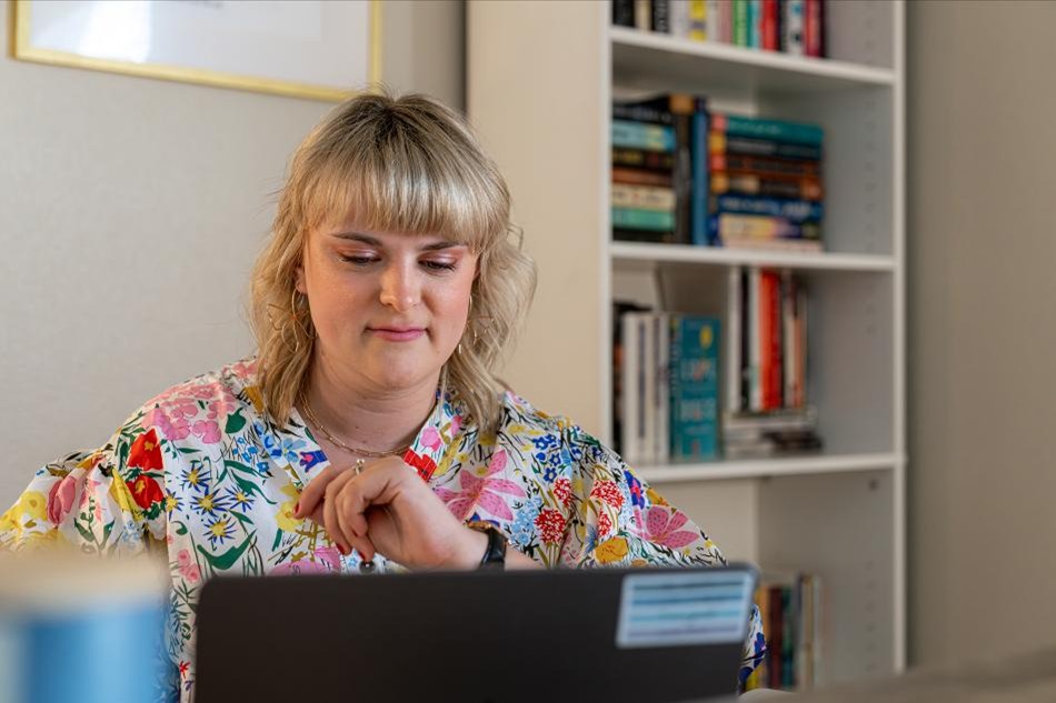 Finances in Order Photo of a Betenbough Homes homeowner working at her computer in a home office.