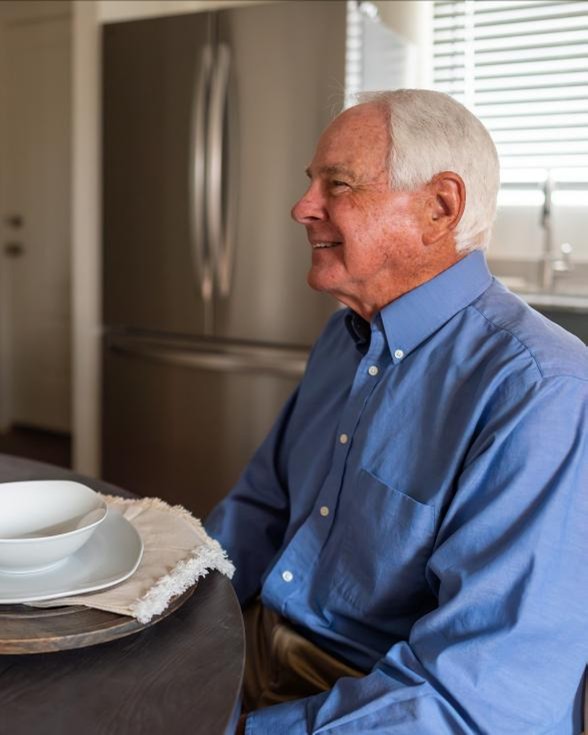 Grandpa Comp Photo of a man sitting at the dining table in his downsized home by Betenbough Homes, West Texas' #1 homebuilder.
