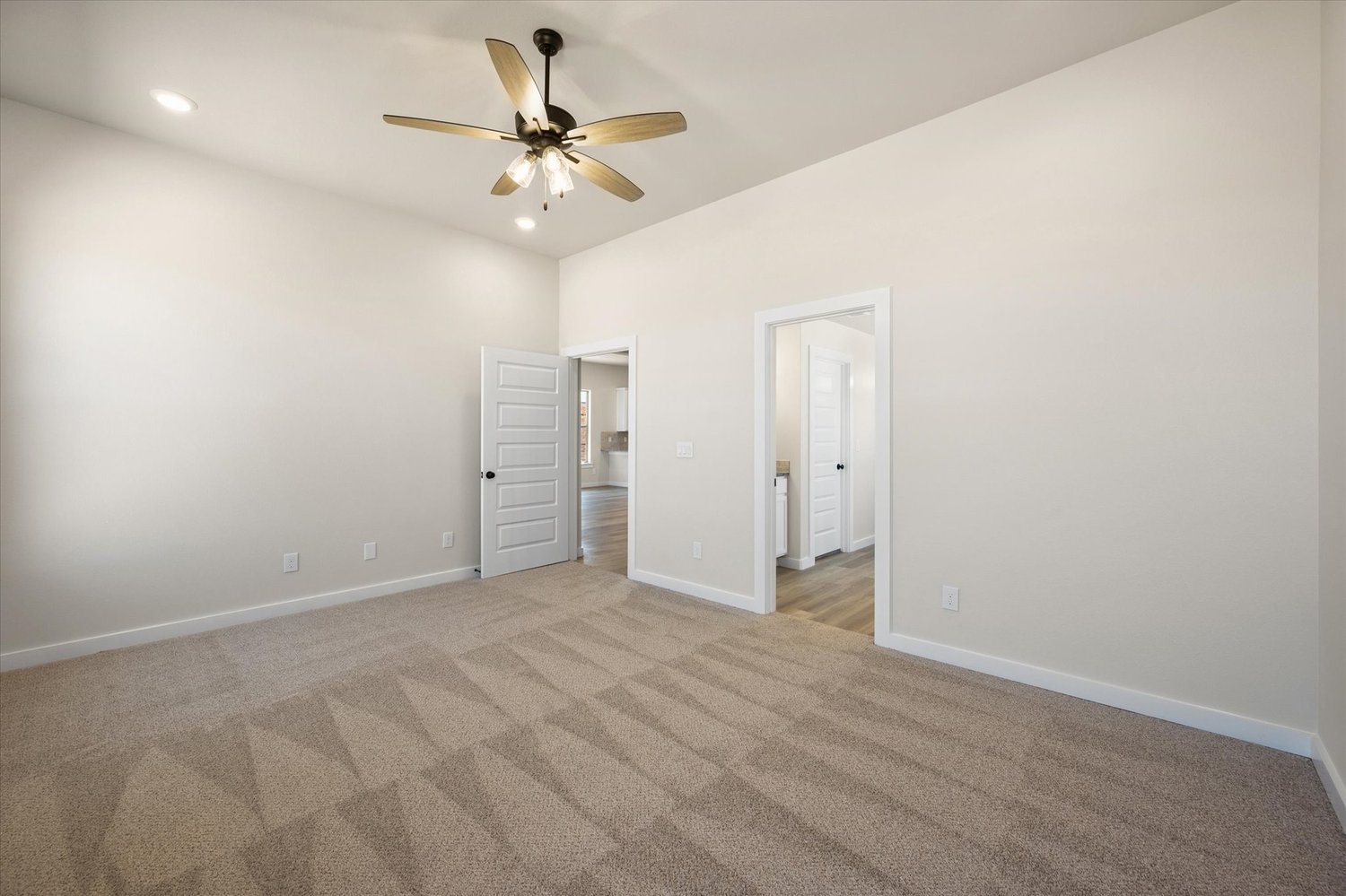 Photo of carpeted bedroom in the Nikki, one of Betenbough's homes with open floor plan.