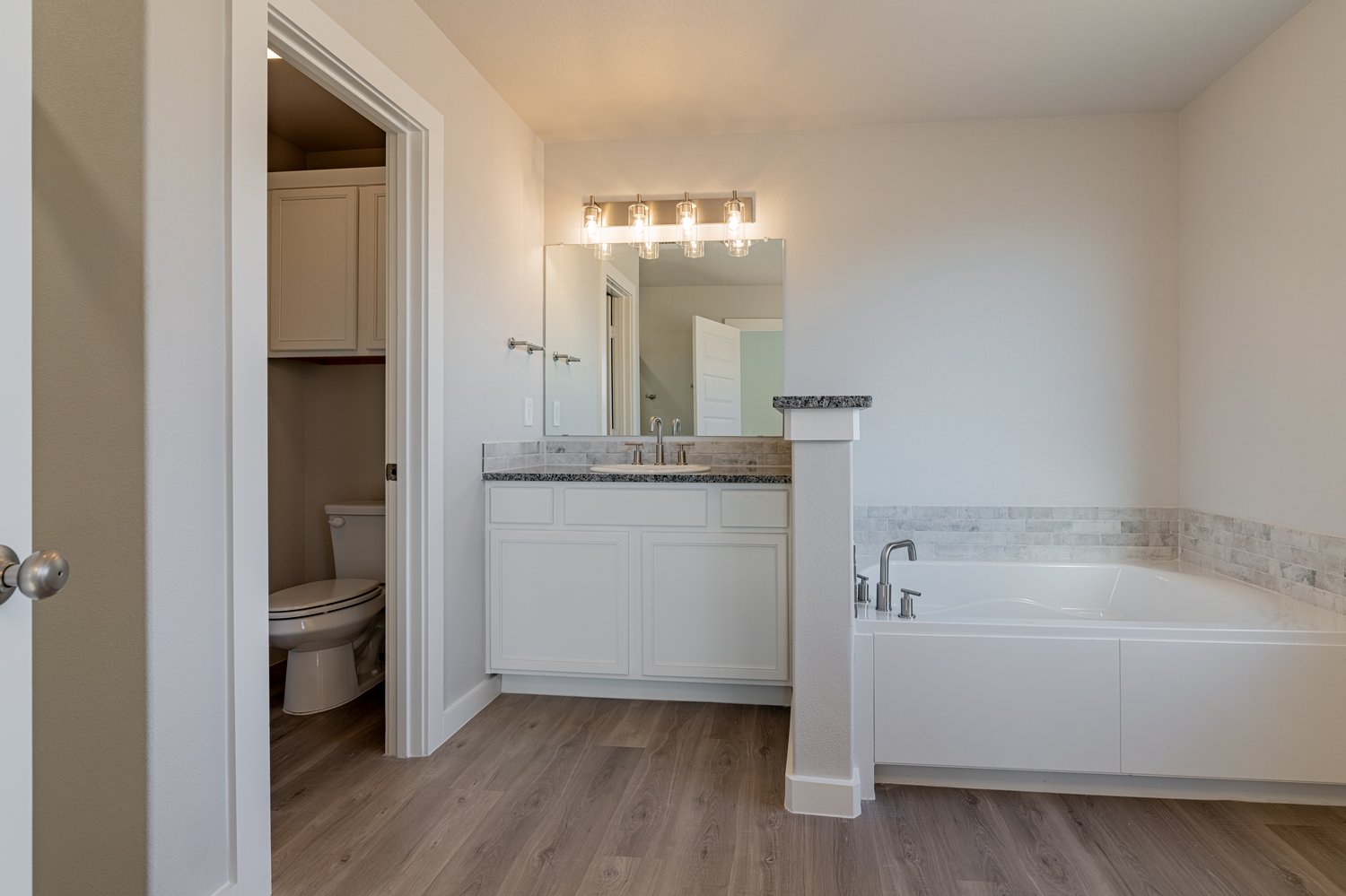 Photo of a garden tub and vanity in the master bathroom of the Layla, a Betenbough home