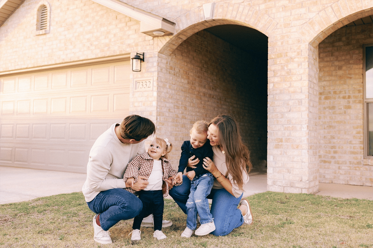 Family laughing outside their home