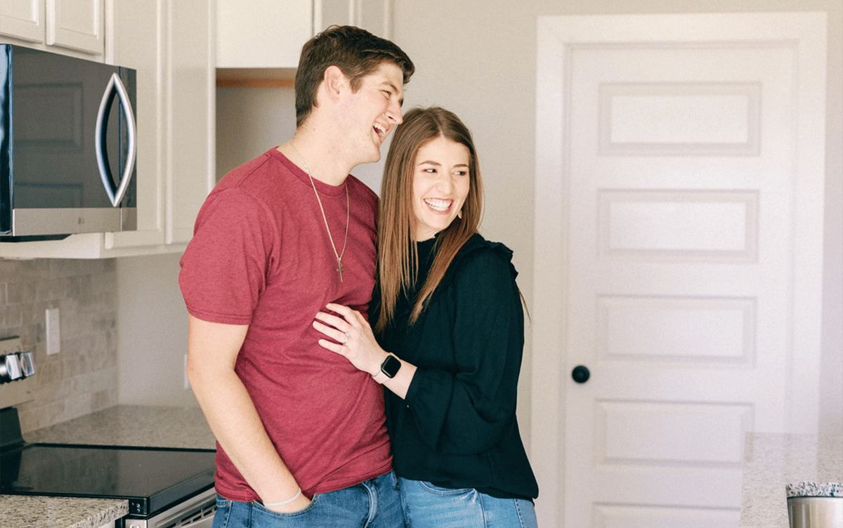 Happy couple smiling together in their Betenbough home kitchen