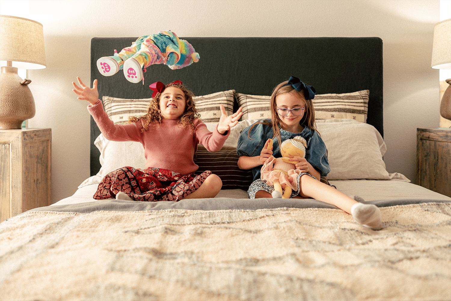 Girls playing with dolls in bed