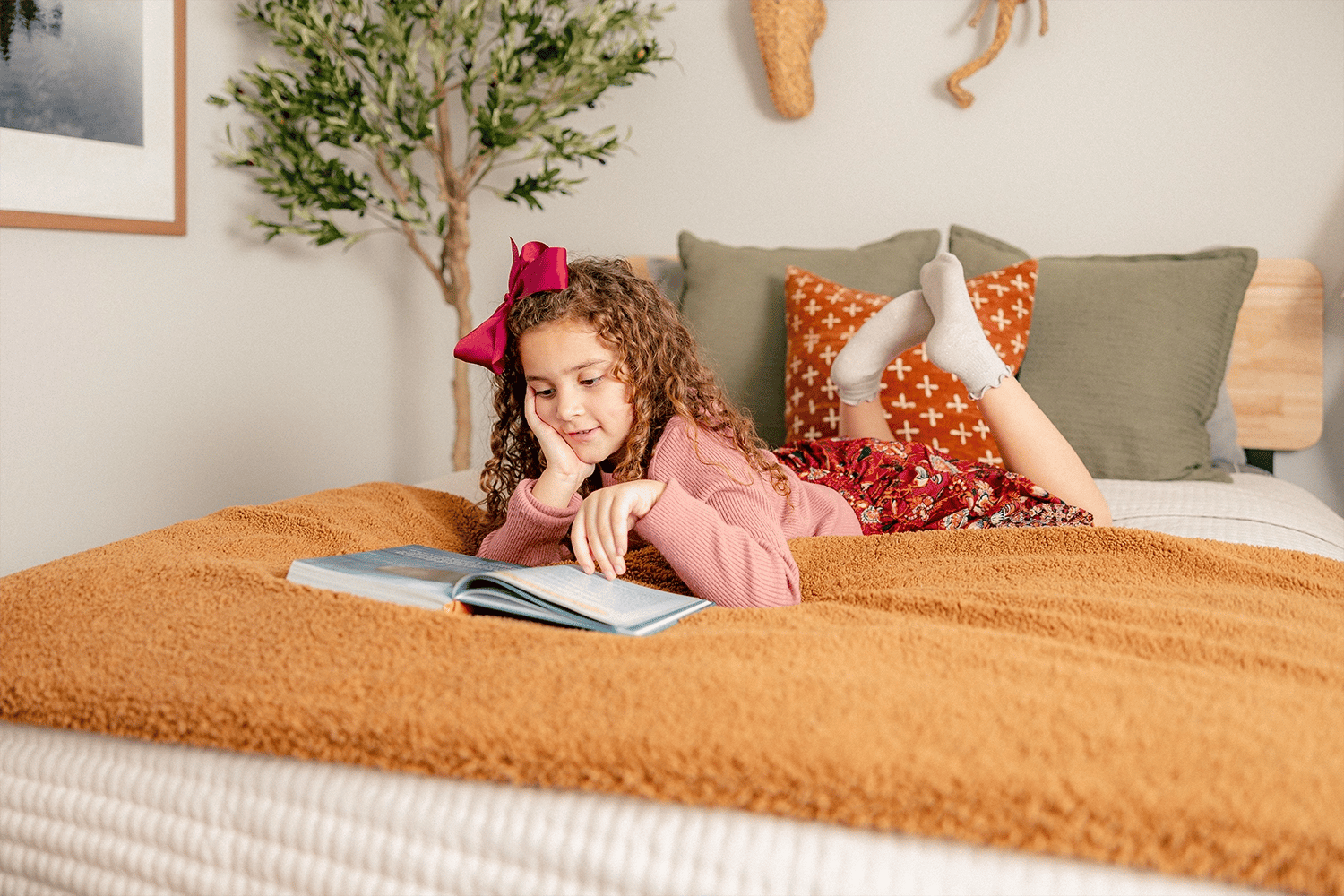 Photo of a young girl reading on her bed in her Betenbough home.