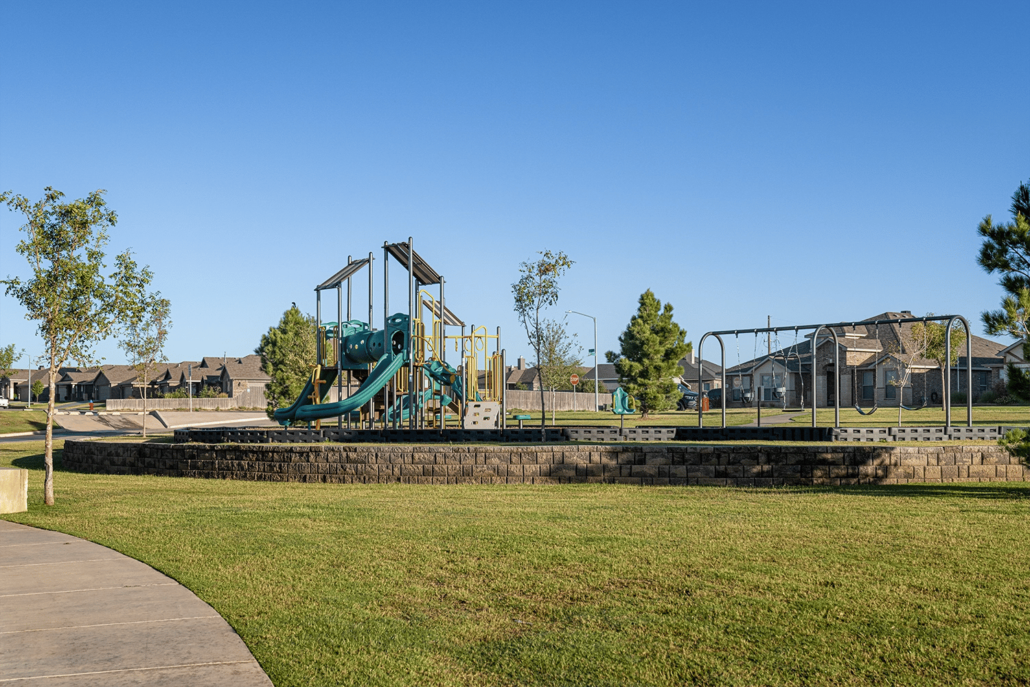 Photo of playground equipment and swings at the park in Bell Farms, a Betenbough Homes community. Betenbough is one of several home builders in Lubbock Tx.