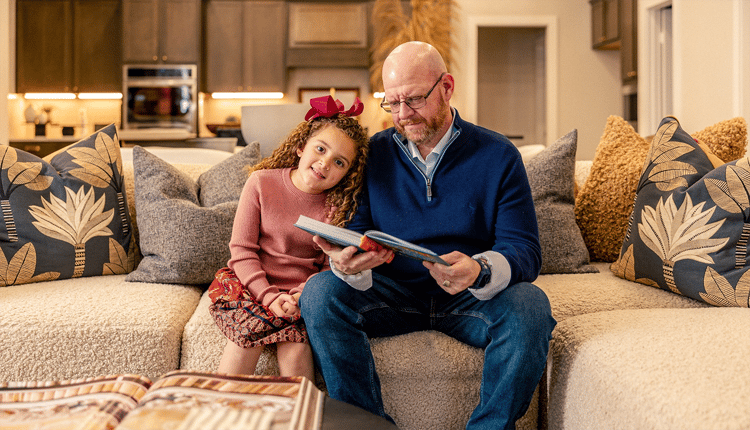 Dad reading with his daughter on couch