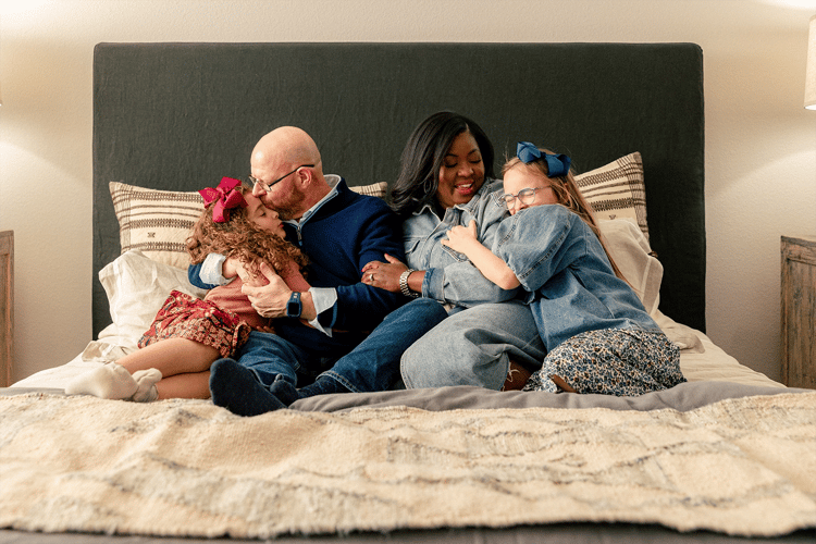 Family hugging in bed