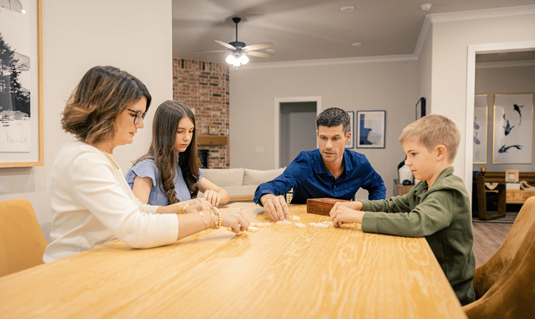 Family playing with dominoes at table