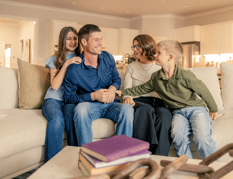 Family laughing together on couch