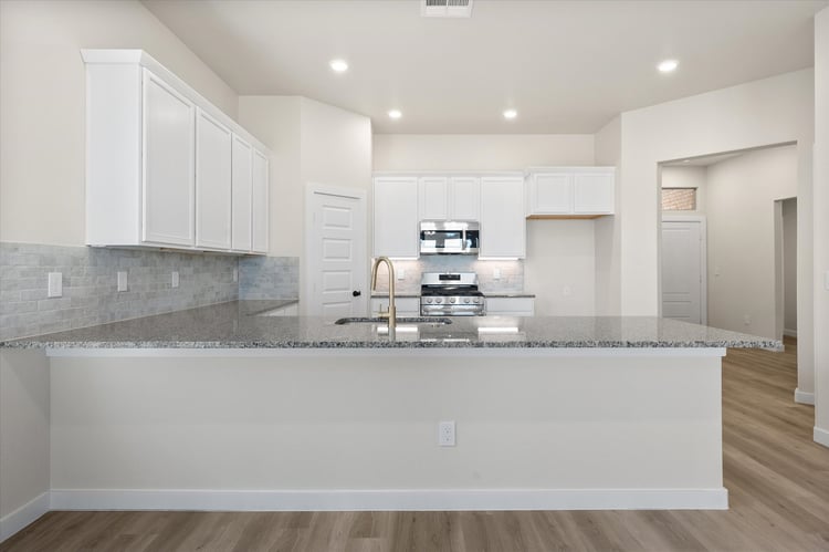 Photo of kitchen as seen from dining area in the Nikki, a Betenbough Homes floor plan.