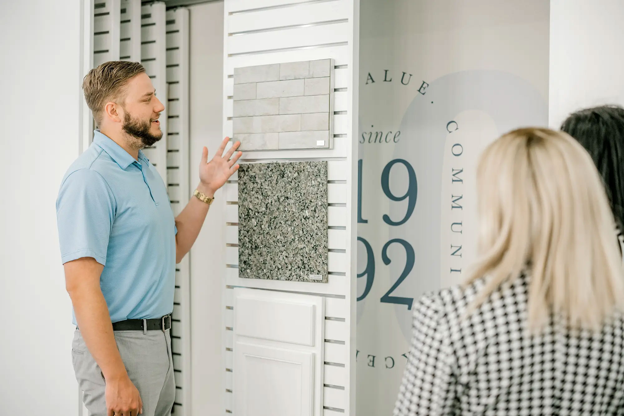 Photo of a Betenbough Homes sales associate going over design options with home buyers.