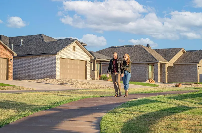 Photo of a couple strolling hand-in-hand on a walking trail in a Betenbough community.