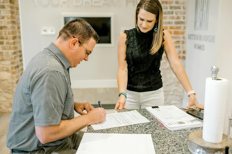 Photo of home buyer signing paperwork.