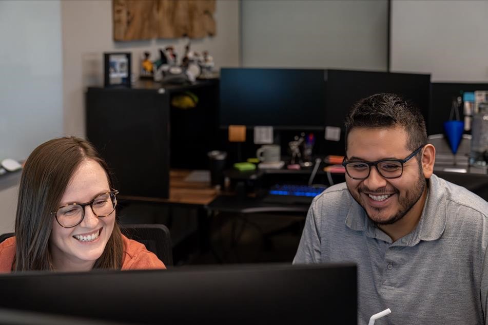 Photo of a man and woman looking at a computer screen.