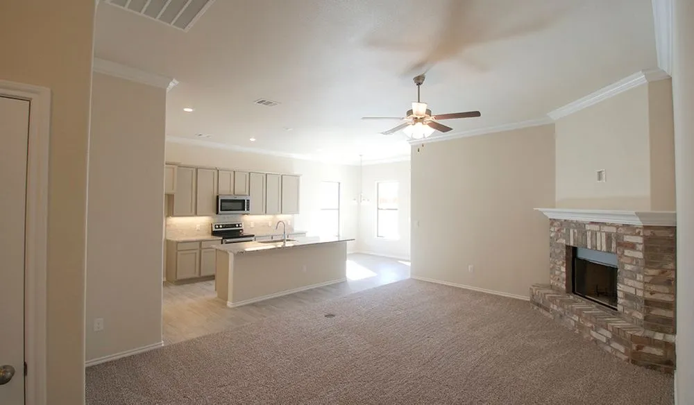 Photo of a Betenbough homes living room, fireplace, kitchen, and dining room.