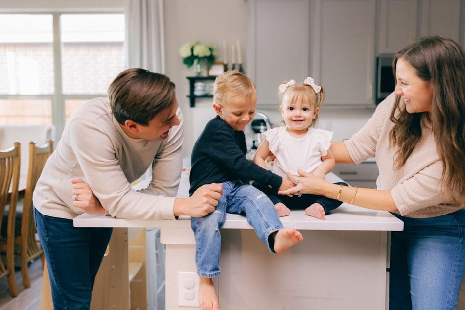 Photo of a family with small children in their Betenbough Homes kitchen.