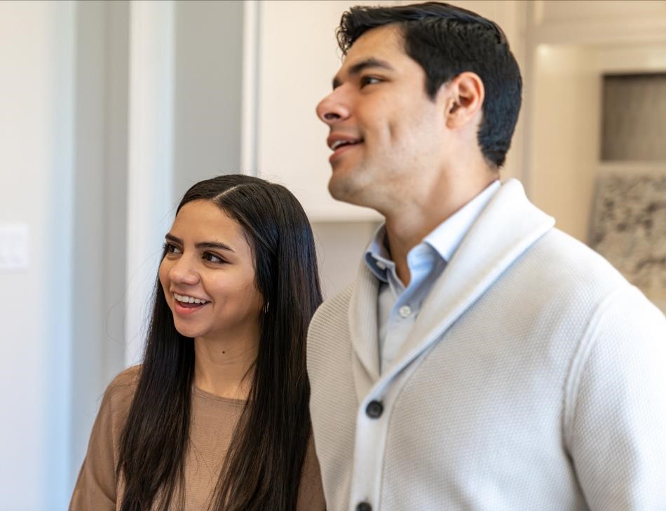 Photo of a husband and wife smiling inside a Betenbough Homes New Home Center.