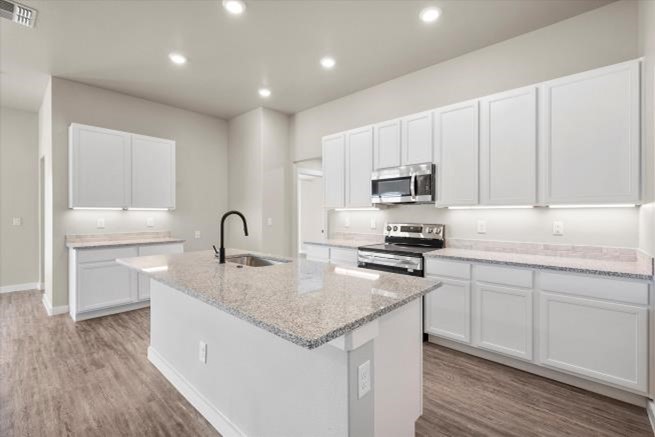 Photo of a beautiful white Betenbough Homes kitchen with island.