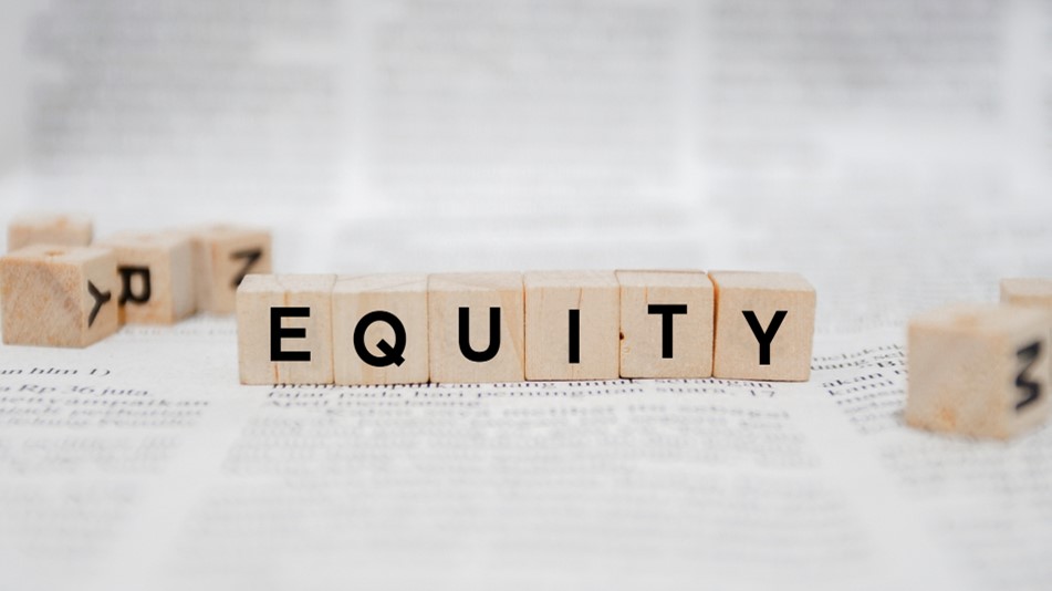 Photo of scrabble tiles spelling 'Equity' among random scrabble tiles all on a dictionary page, representing building equity by using your tax return as a down payment on a new home.