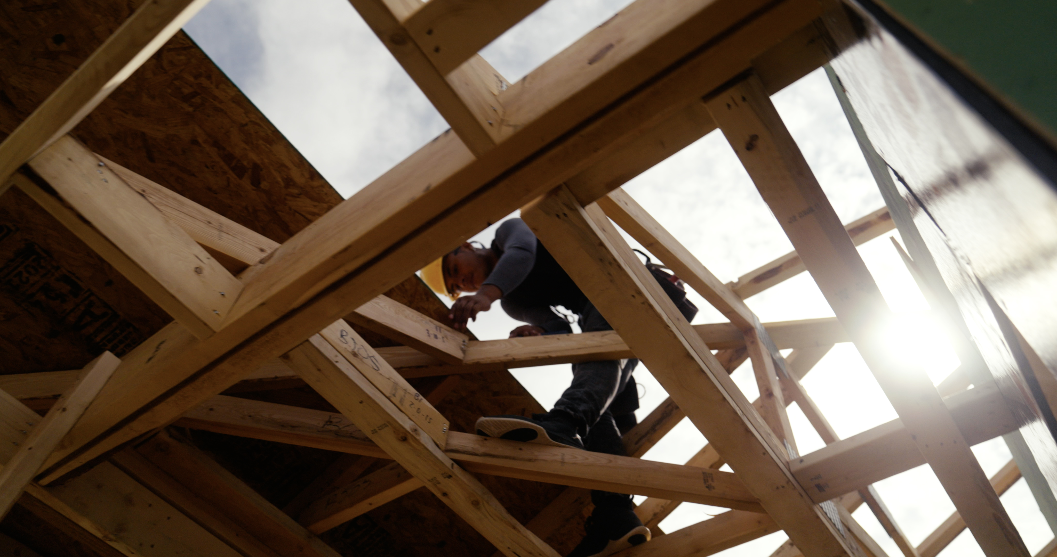 Photo of a trade partner putting roofing materials on a framed, energy-efficient Betenbough home.