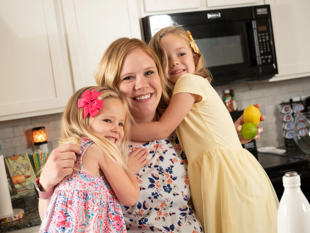 Photo of a mom with her daughters in the kitchen of their Betenbough home.