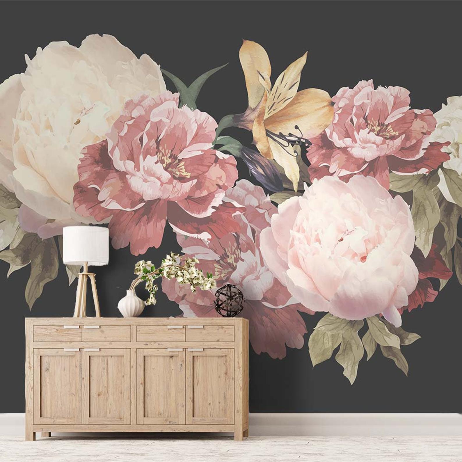 Photo of a decorated home entryway with a floral mural on the wall and a sideboard topped with a lamp, plant, and decorative sphere.