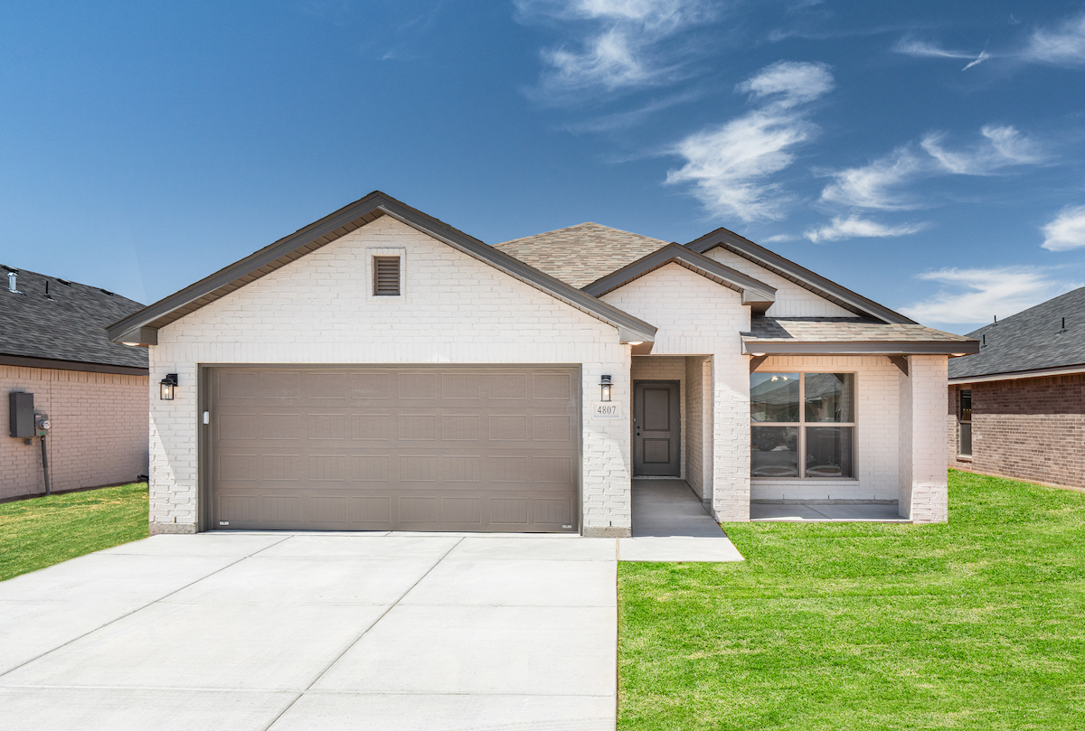 Photo of Betenbough Home's Mia floor plan with white painted brick, a covered entry way, and brick columns.