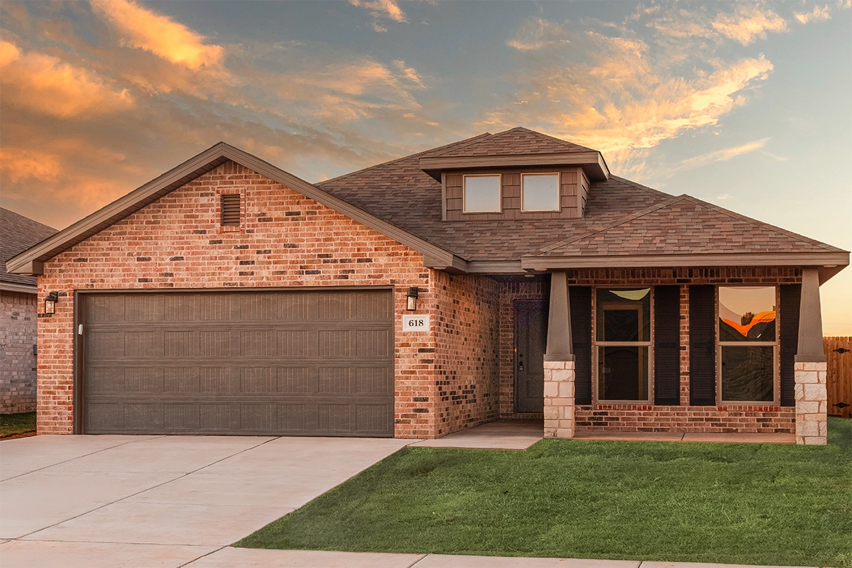 Photo of the exterior of a Betenbough home with stone accents, a lush lawn, and a West Texas sky in the background.