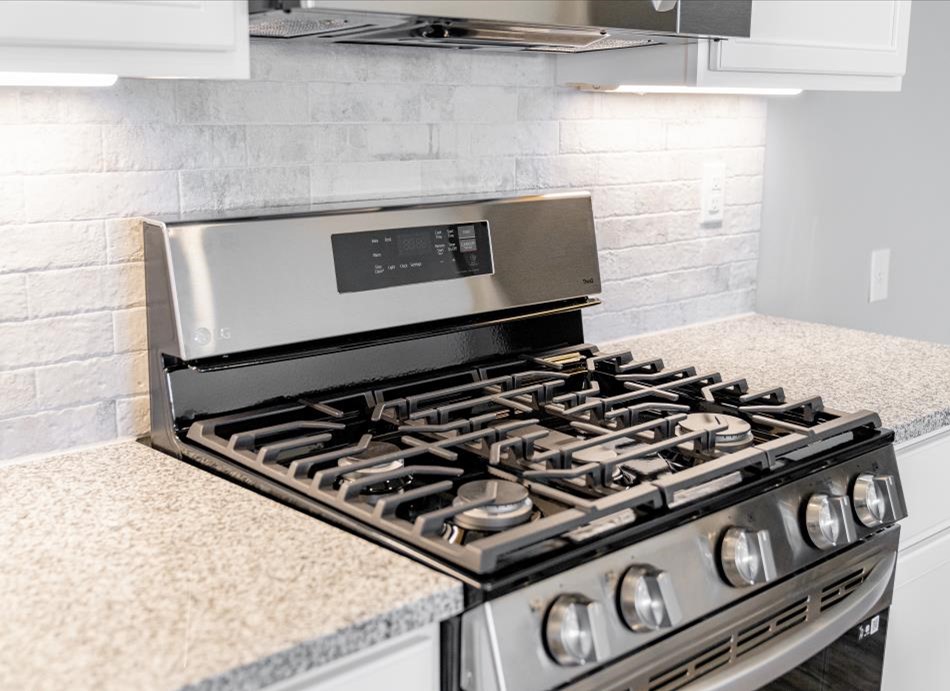 Photo of a gas oven and range in a Betenbough Home representing proper cleaning and maintenance of this appliance.