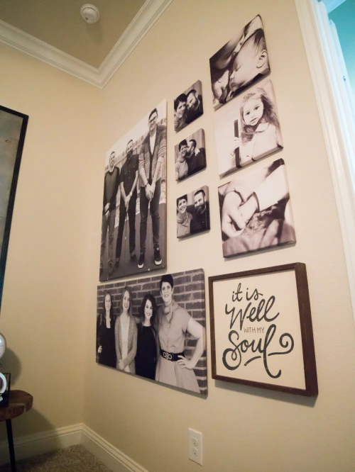 Photo of a grouping of family photos on the bedroom wall.