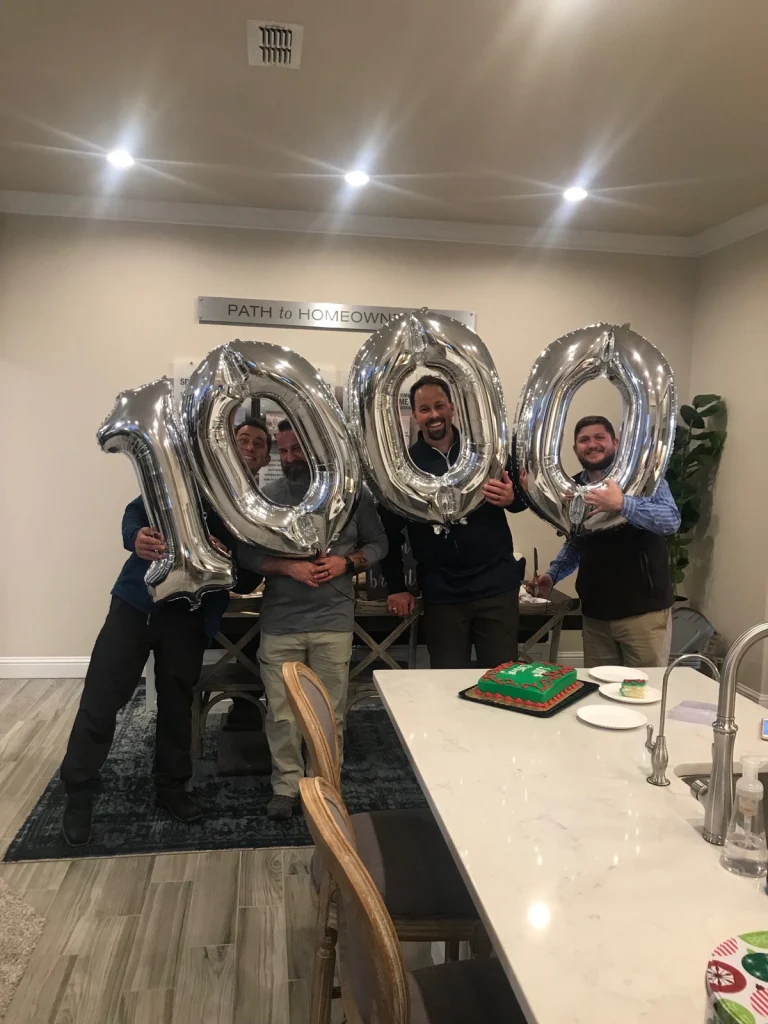 Photo of the Bell Farms team celebrating with cake and balloons.