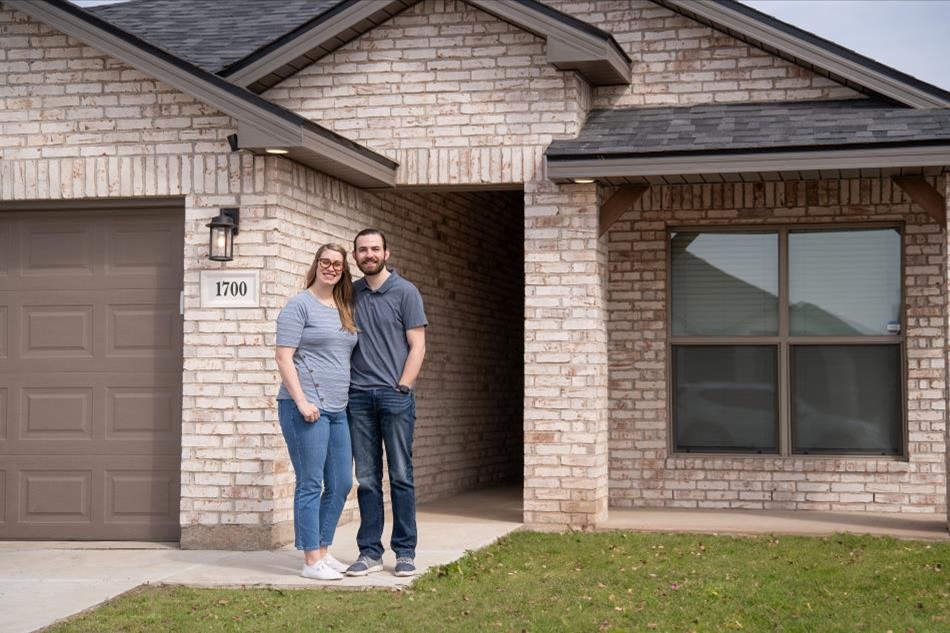 Photo of two homeowners standing in front of their Betenbough home.