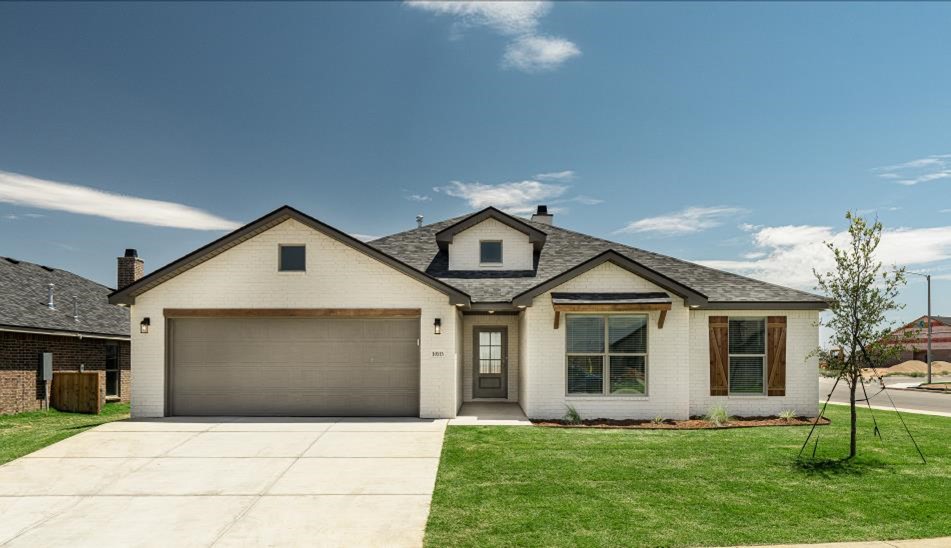 Photo of a Betenbough home with an established yard and tree in the front.