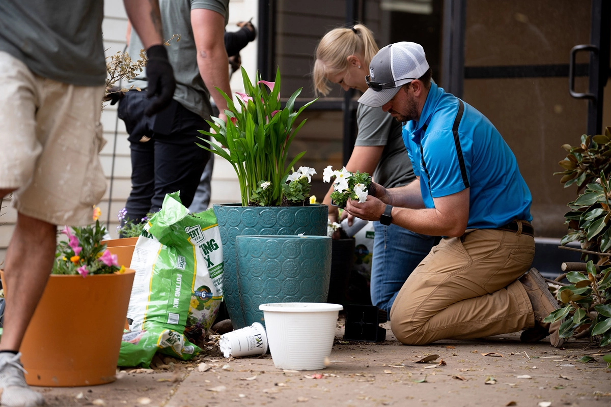 Betenbough employee planting flowers in a pot for a giveback opportunity