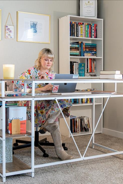 Photo of a first-time home buyer working in her home office in her Betenbough home.