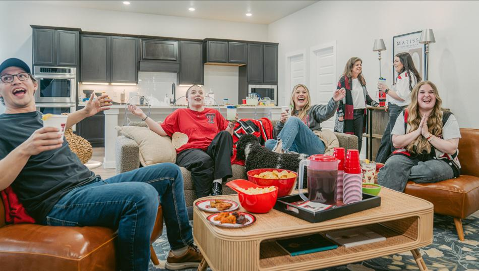 Photo of Tech fans watching a game in a Betenbough home.