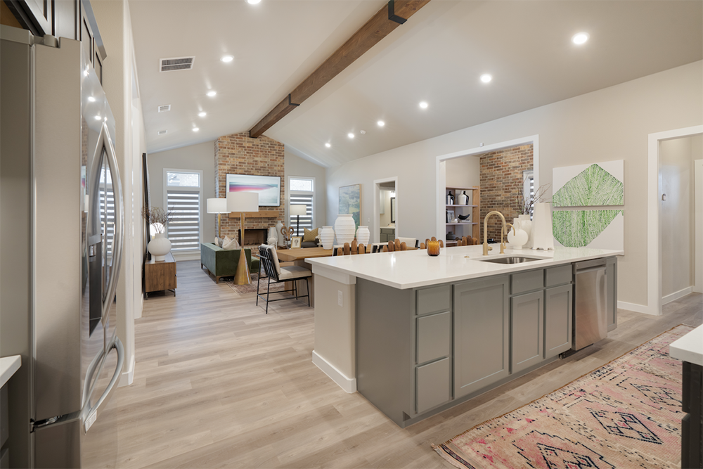 Photo of the Parade Home's kitchen island. The dining table and furnished living room is visible in the background.