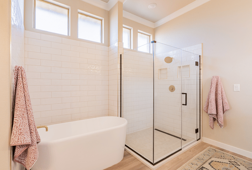 Photo of the Parade Home's master bathroom with a glass shower and free-standing tub.