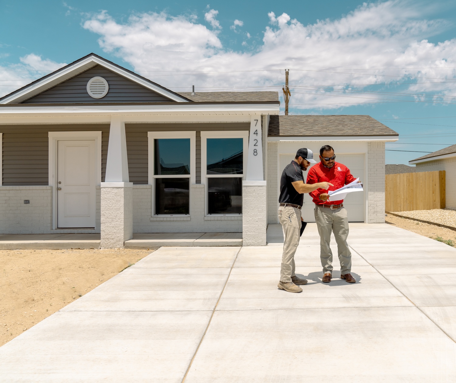 Two Betenbough employees looking at the blue print of a home.