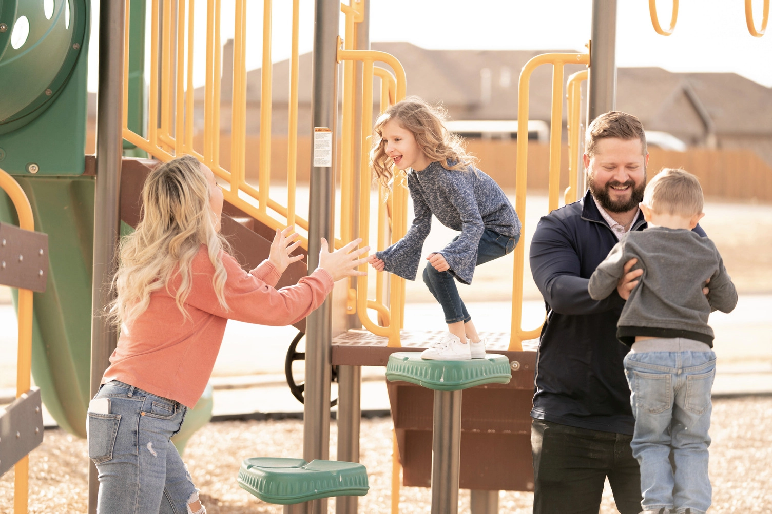 Family playing on playground in Midland, TX Betenbough neighborhood